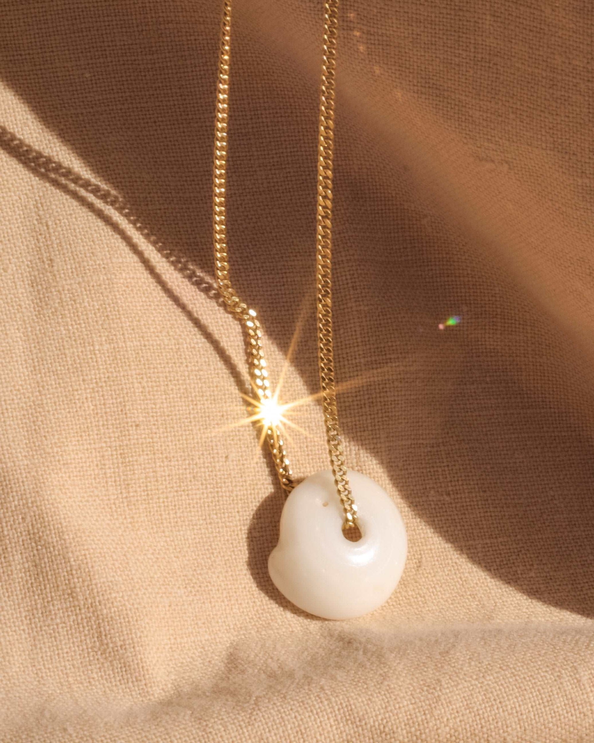 seashell gold necklace glistening in the sun