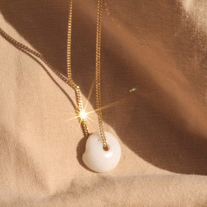 seashell gold necklace glistening in the sun